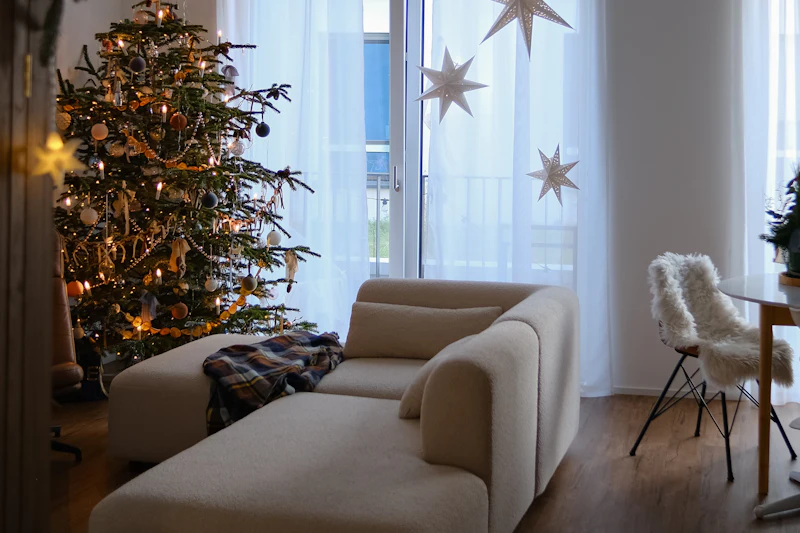 Salón decorado para Navidad con árbol iluminado y estrellas de papel